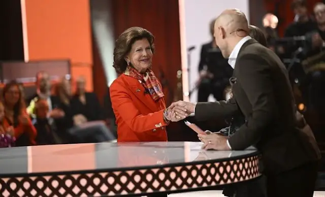 Queen Silvia wore a coral blazer by Georg et Arend. Chanel multicolour silk scarf. Fundraising campaign for Ukraine's children