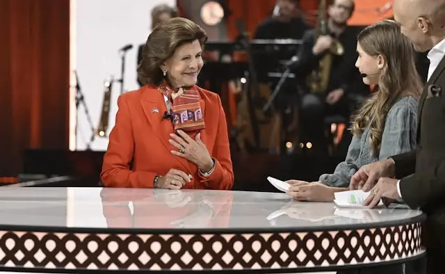 Queen Silvia wore a coral blazer by Georg et Arend. Chanel multicolour silk scarf. Fundraising campaign for Ukraine's children