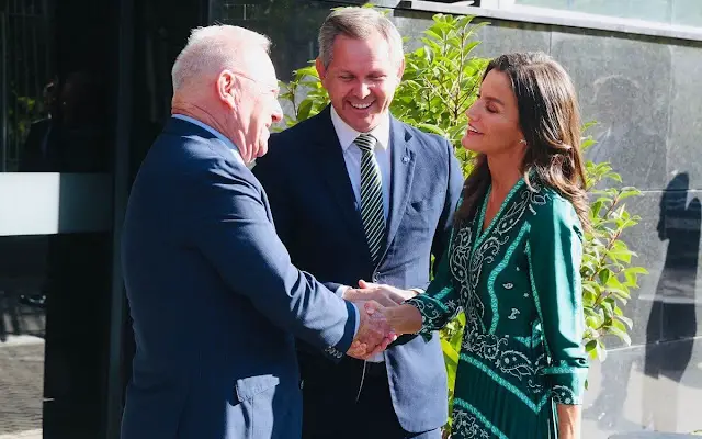 Queen Letizia wore a green scarf print midi dress by Sandro. Carolina Hererea black leather bag. Carolina Herrera pumps