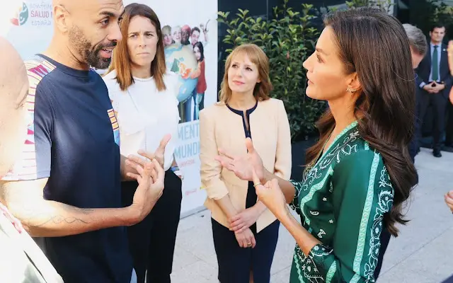 Queen Letizia wore a green scarf print midi dress by Sandro. Carolina Hererea black leather bag. Carolina Herrera pumps