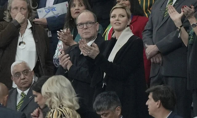 Princess Charlene wore a black wool coat by Akris. Gold hoop earrings. South Africa national rugby union team Springboks