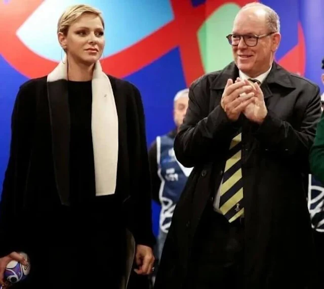 Princess Charlene wore a black wool coat by Akris. Gold hoop earrings. South Africa national rugby union team Springboks