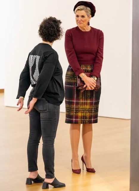 Queen Maxima wore a burgundy top by Natan. She wore a wool midi skirt by Natan. Günay Uslu and visual artist Jonas Staal