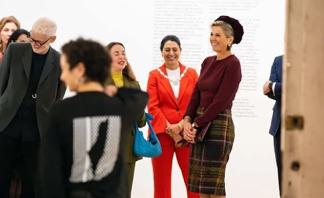 Queen Maxima wore a burgundy top by Natan. She wore a wool midi skirt by Natan. Günay Uslu and visual artist Jonas Staal