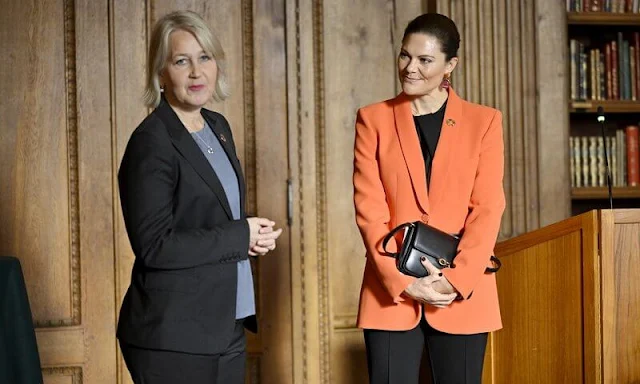 Crown Princess Victoria wore an orange shawl lapel blazer by Zara. By Malina black silk blouse. Black trousers