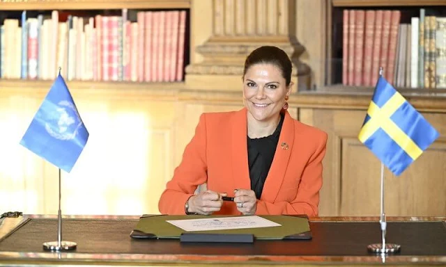 Crown Princess Victoria wore an orange shawl lapel blazer by Zara. By Malina black silk blouse. Black trousers