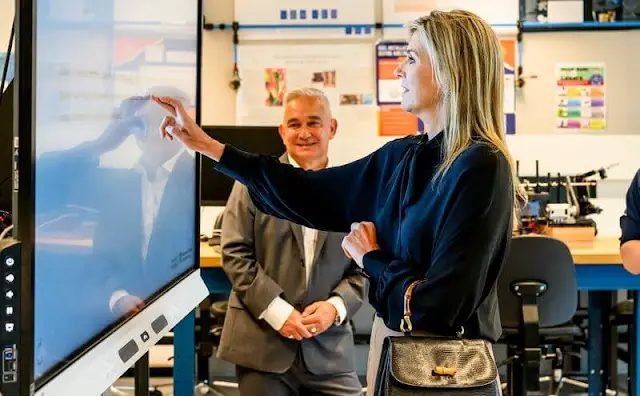 Queen Maxima wore a wool midi skirt by Massimo Dutti. COS draped collar black blouse. Artificial Intelligence Centre