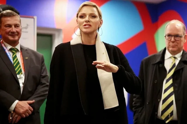 Princess Charlene wore a black wool coat by Akris. Gold hoop earrings. South Africa national rugby union team Springboks