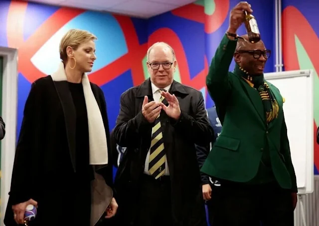 Princess Charlene wore a black wool coat by Akris. Gold hoop earrings. South Africa national rugby union team Springboks