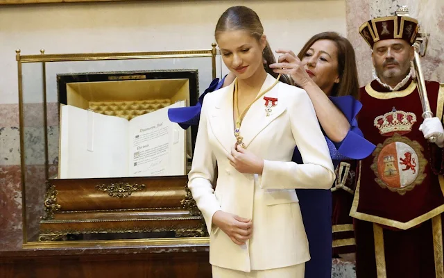 Princess Leonor wore a white suit by Sastreria Serna. Queen Letizia in Carolina Herrera. Infanta Sofia wore a Verdie dress by Erdem