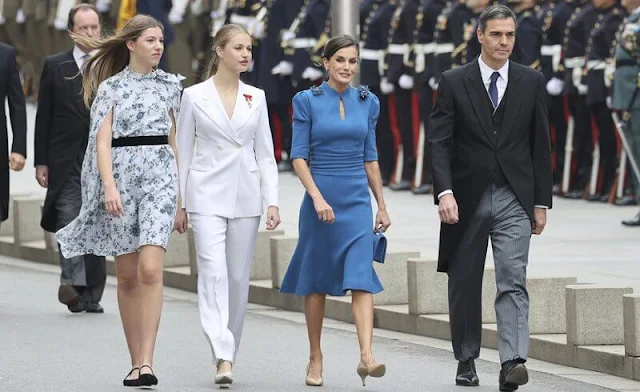 Princess Leonor wore a white suit by Sastreria Serna. Queen Letizia in Carolina Herrera. Infanta Sofia wore a Verdie dress by Erdem