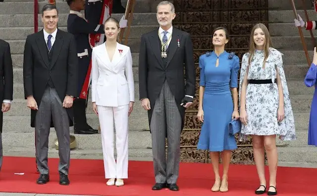 Princess Leonor wore a white suit by Sastreria Serna. Queen Letizia in Carolina Herrera. Infanta Sofia wore a Verdie dress by Erdem