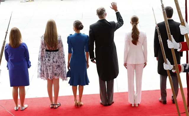 Princess Leonor wore a white suit by Sastreria Serna. Queen Letizia in Carolina Herrera. Infanta Sofia wore a Verdie dress by Erdem