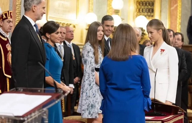 Princess Leonor wore a white suit by Sastreria Serna. Queen Letizia in Carolina Herrera. Infanta Sofia wore a Verdie dress by Erdem