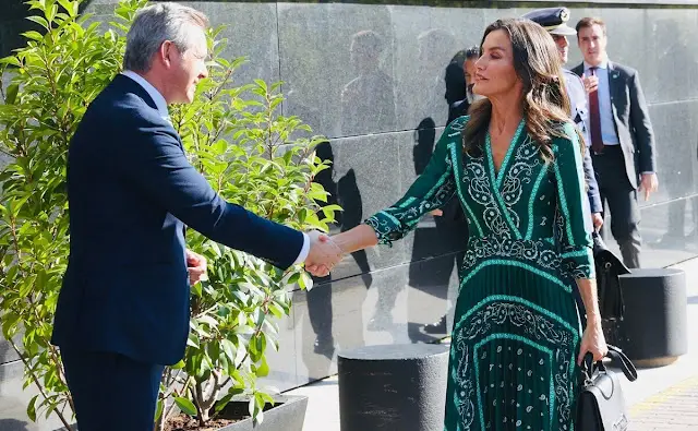 Queen Letizia wore a green scarf print midi dress by Sandro. Carolina Hererea black leather bag. Carolina Herrera pumps