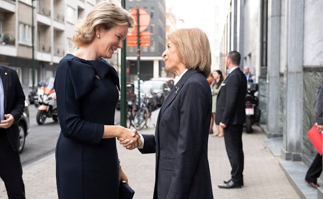 Queen Mathilde wore a new navy blue Structured scuba midi dress by Natan. European Commissioner Stella Kyriakides