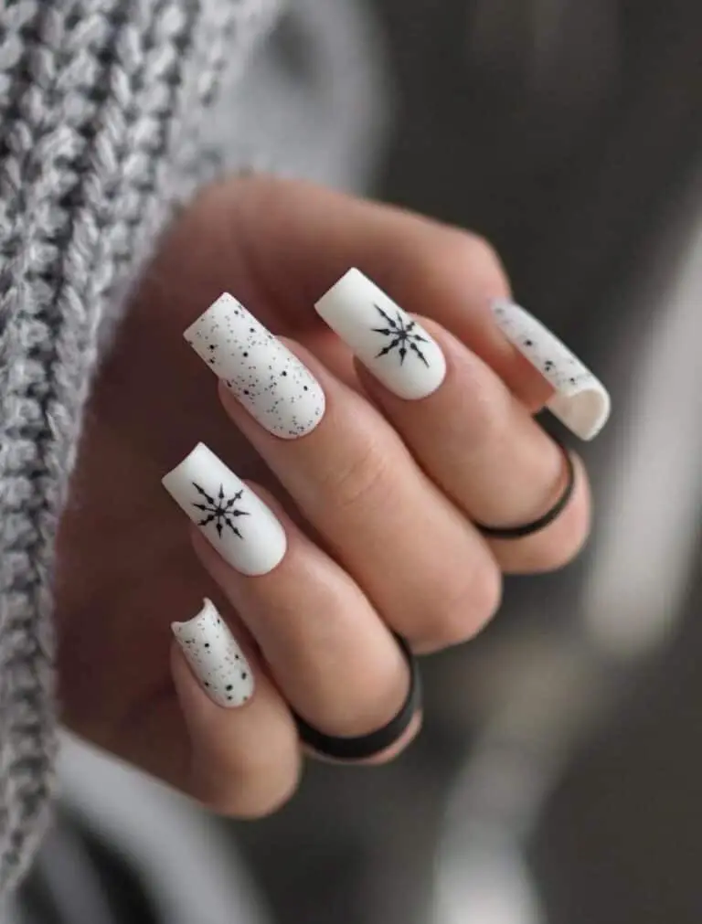 White Nails with Black Speckles and Snowflake Accents