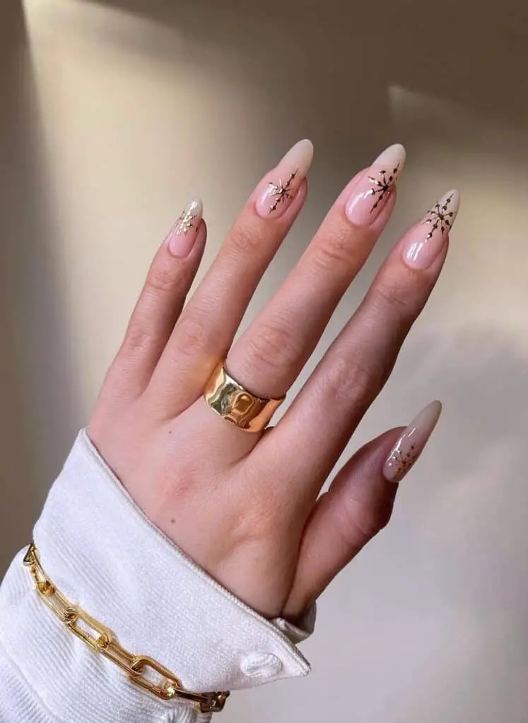 Gold Snowflakes on Nude Nails: Chic Winter Nail Designs