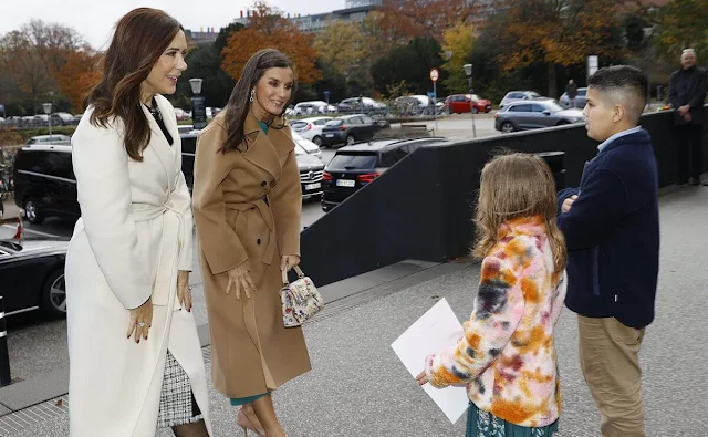 Queen Letizia wore a green ranglan green midi dress by Dandara. Carolina Herrera camel wool coat