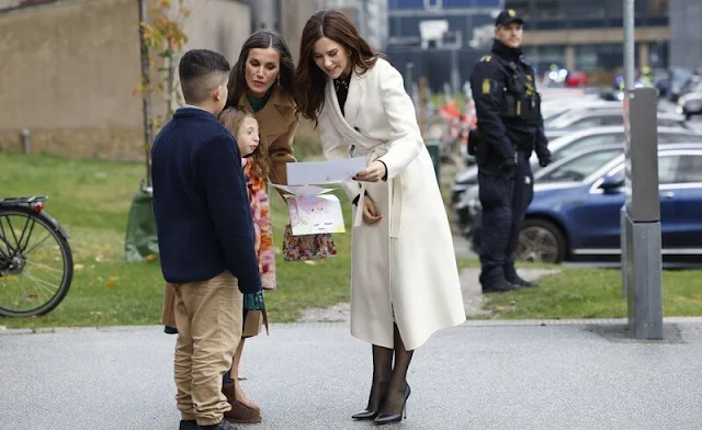 Queen Letizia wore a green ranglan green midi dress by Dandara. Carolina Herrera camel wool coat