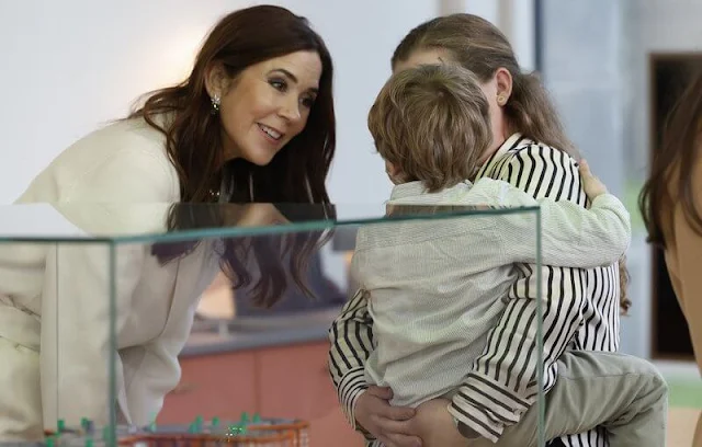 Queen Letizia wore a green ranglan green midi dress by Dandara. Carolina Herrera camel wool coat