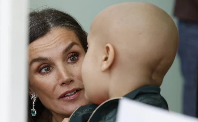 Queen Letizia wore a green ranglan green midi dress by Dandara. Carolina Herrera camel wool coat