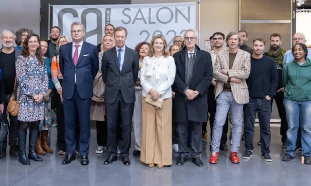 Princess Stephanie wore a white silk blouse by Paule Ka. Beige camel wide leg pants. Grand Duke Henri of Luxembourg