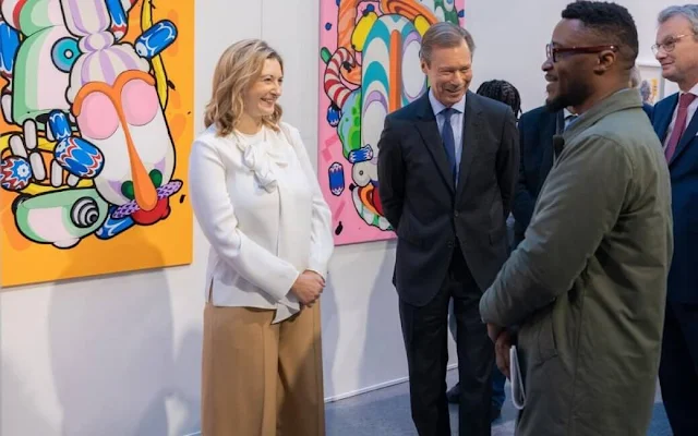 Princess Stephanie wore a white silk blouse by Paule Ka. Beige camel wide leg pants. Grand Duke Henri of Luxembourg