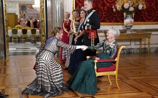 Queen Letizia wearing Felipe Varela navy gown. Crown Princess Mary wearing Lasse Spangenberg gown