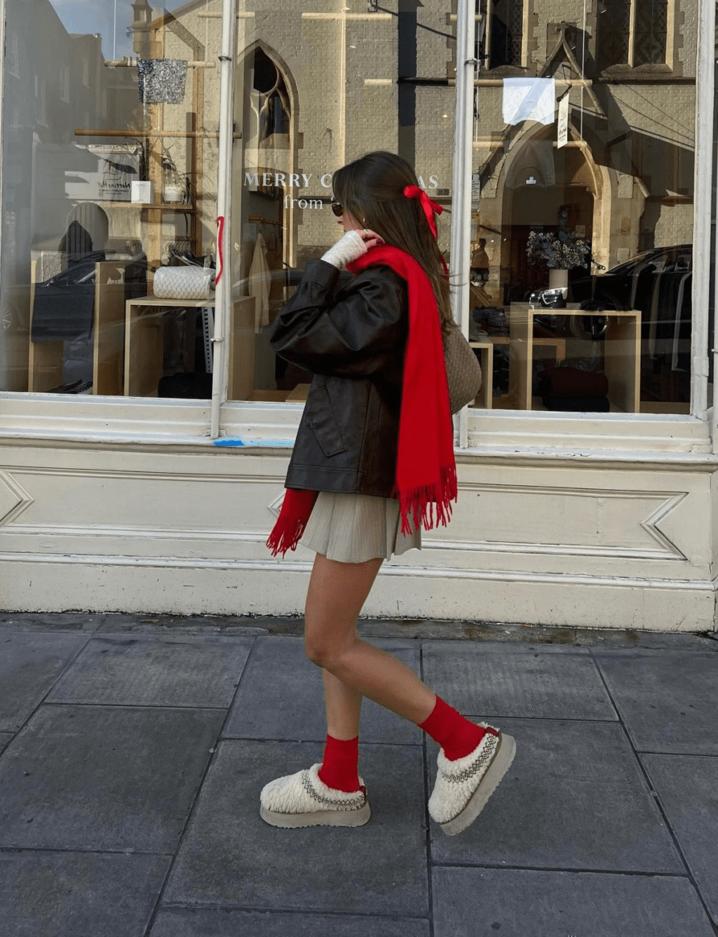 Pair a dark brown jacket with a beige mini skirt, and complement it with cream shearling UGGs. Add a bright red scarf and matching red socks 