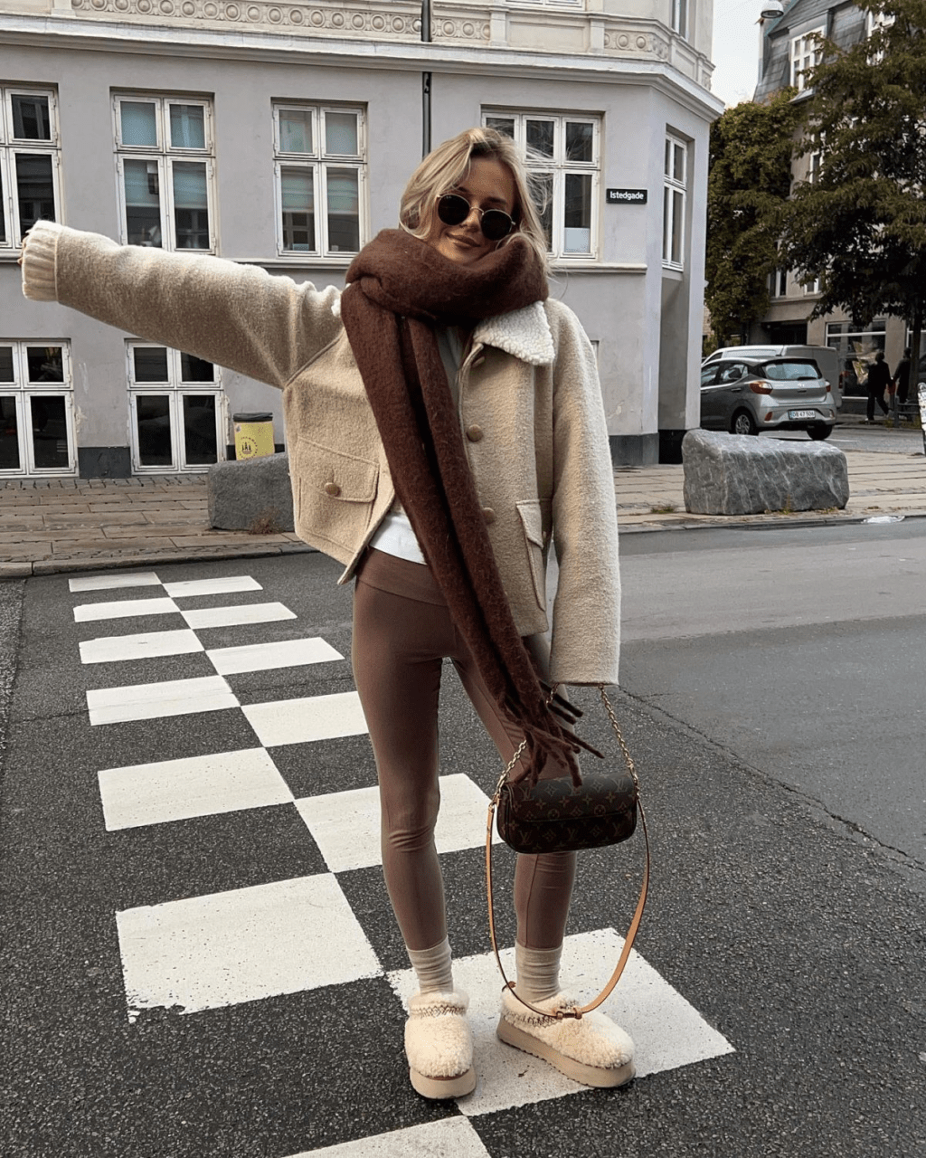 Try styling shearling UGG Tasman slippers with a white t-shirt, brown leggings, and a dark brown scarf. Top it off with a beige teddy jacket 