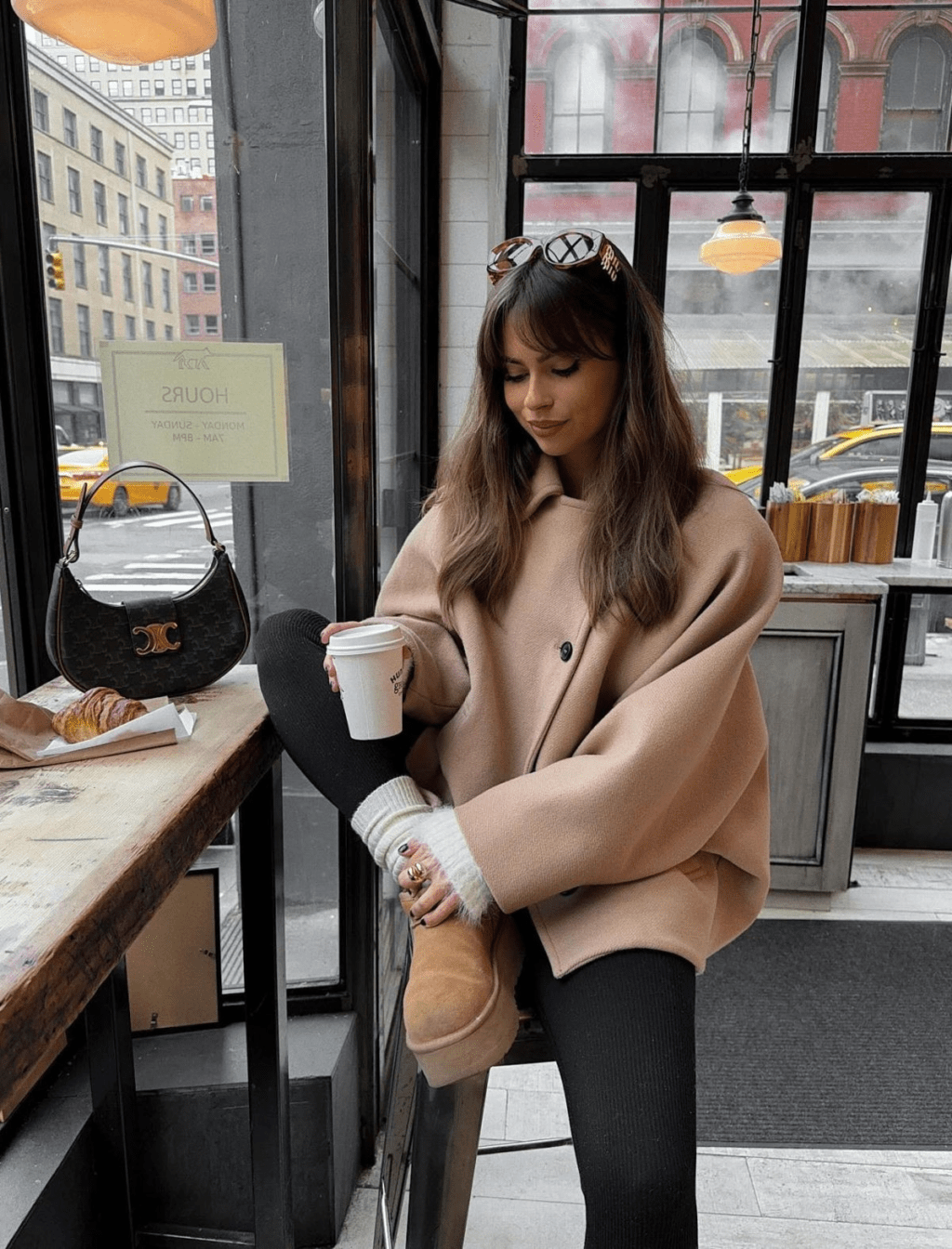  This outfit combines caramel-colored UGG boots with black leggings, thick white socks, and a boxy caramel jacket.